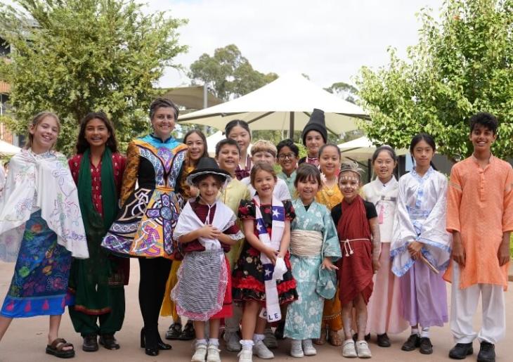 Junior  students dress in cultural attire standing together 